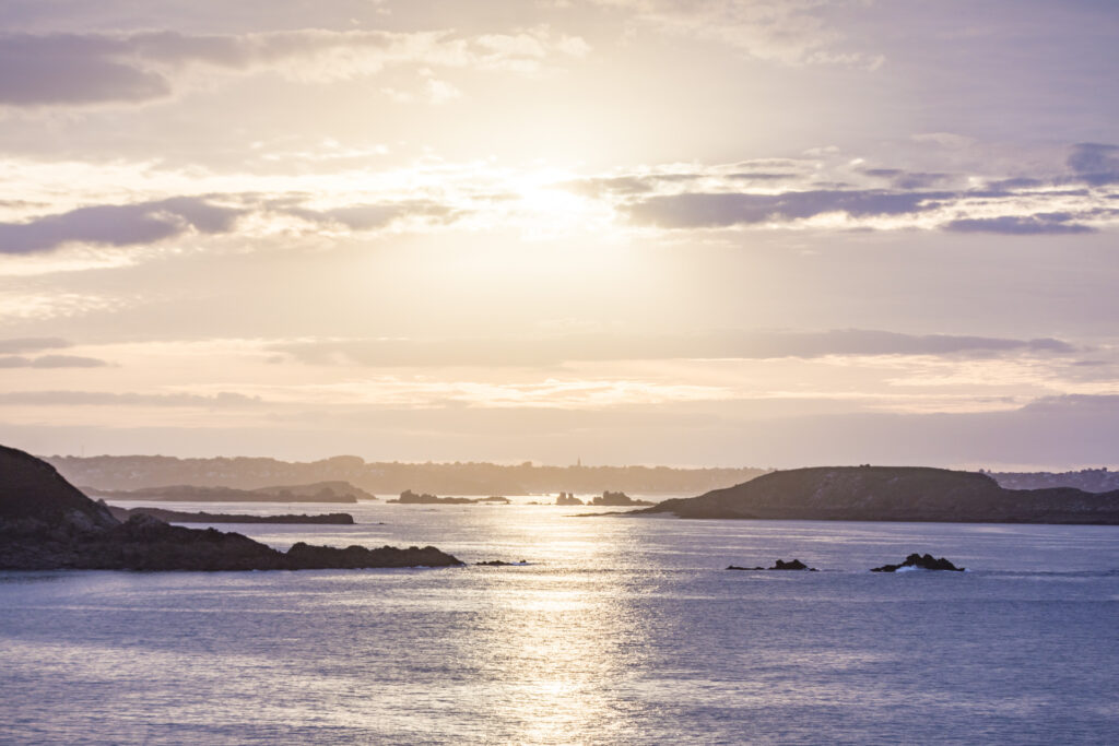 Coucher De Soleil aux tons mauve vu de Saint Lunaire. Le panorama offre des vues sur la Manche, l'île Agot de Saint-Briac-sur-Mer, la Baie de Lancieux et le clocher de Saint-Jacut de la Mer.