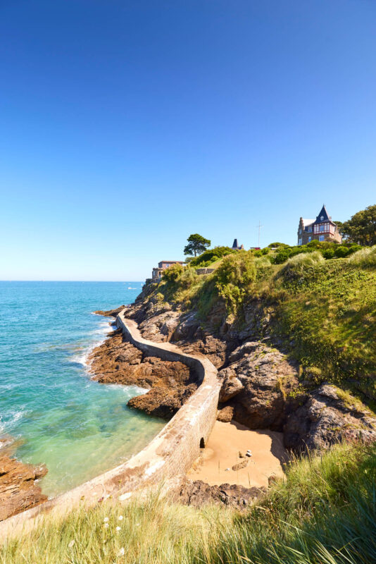 En hauteur du Gr34, sentier côtier parcourant les 2000 kilomètres de côtes bretonnes. Entre La Pointe De La Malouine Et le quartier de Saint Enogat, le circuit de Dinard passe entre la mer turquoise et les villas Belle-Epoque.