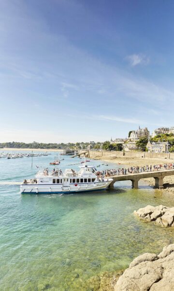 Un groupe de personne attend en ligne d'embarquer en excursion sur la navette de la Compagnie Corsaire à Dinard, sur la Promenade du Clair de Lune.