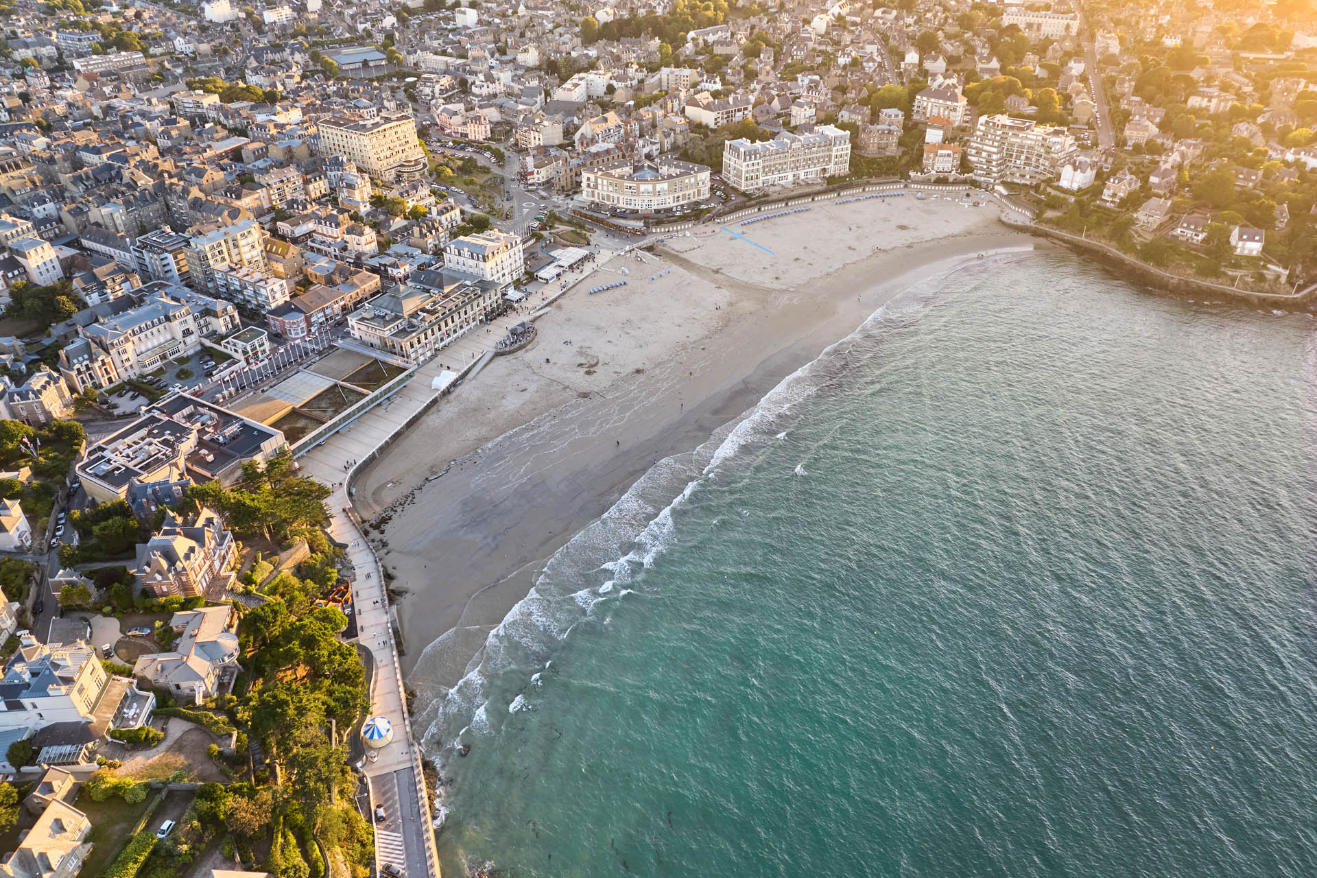 Vue aérienne de la Plage de l'Ecluse à Dinard. Joli contraste entre le bleu de l'eau et les batiments du centre-ville aux tons blanc des murs et gris des ardoises sur les toits.