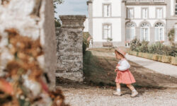 Une petit fille en robe rose et chapeau de paille se balade dans les allées du jardin de la Malouinière Du Montmarin à Pleurtuit, sur les bords de l'estuaire de la Rance, en Bretagne.