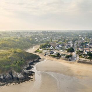 Vue aérienne de la Grande plage De Saint Lunaire en Bretagne et du Goulet, où se jette le Crèvelin, petit court d'eau. A l'est, la Pointe du Nick et sa végétation basse et à l'ouest, le centre-ville de Saint-Lunaire et en particulier son Yacht Club.