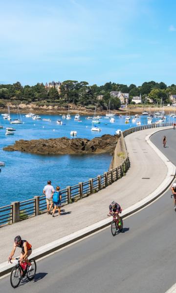 Des vélos de triathlon alignés sur le balcon d'Émeraude à Saint-Briac, prêts pour la course, offrant une vue pittoresque sur le cadre magnifique de la compétition.