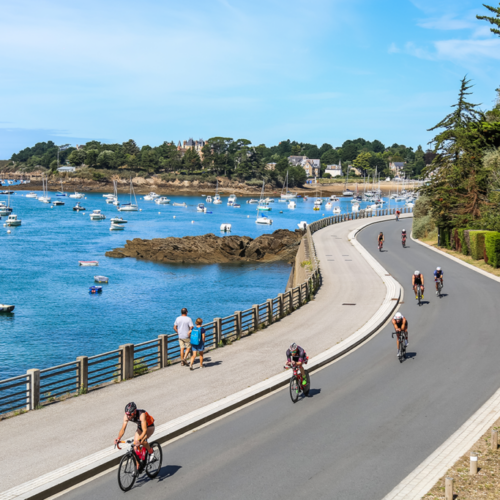 Des vélos de triathlon alignés sur le balcon d'Émeraude à Saint-Briac, prêts pour la course, offrant une vue pittoresque sur le cadre magnifique de la compétition.