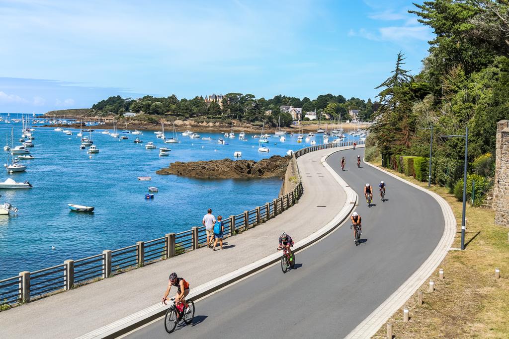 Des vélos de triathlon alignés sur le balcon d'Émeraude à Saint-Briac, prêts pour la course, offrant une vue pittoresque sur le cadre magnifique de la compétition.