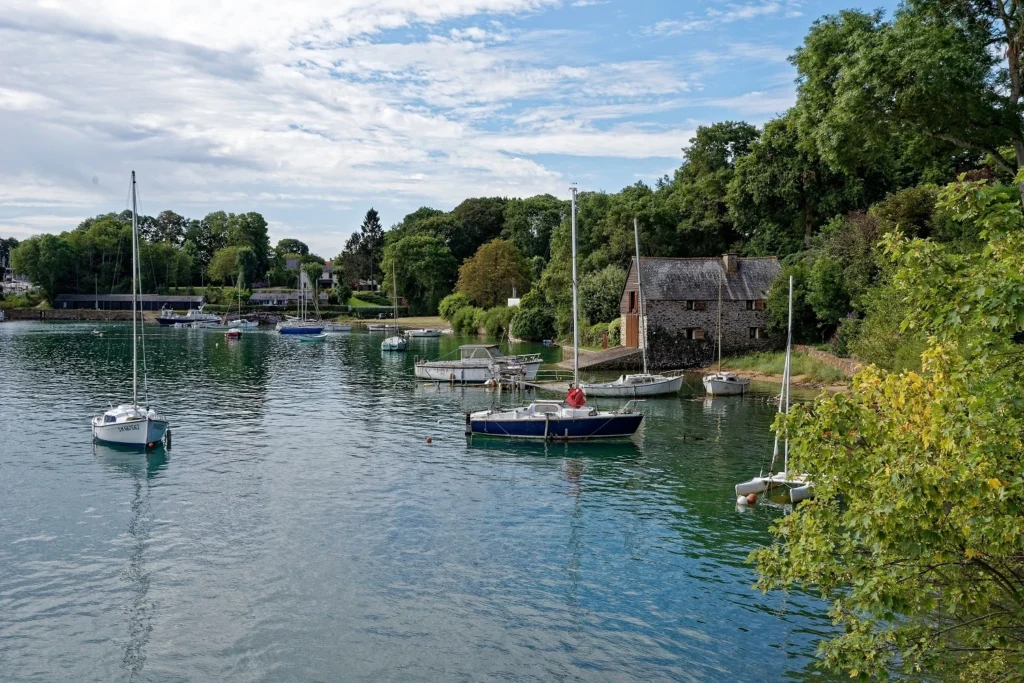 Des bateaux sur l'eau devant la cale de la Landriais au Minihic-sur-Rance, sur les bords de l'estuaire de la Rance.