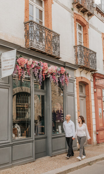 Un couple se promène dans le Centre Ville De Saint Lunaire. Un lieu de rencontre au coeur de la station balnéaire avec des boutiques indépendantes et des commerces de proximité.