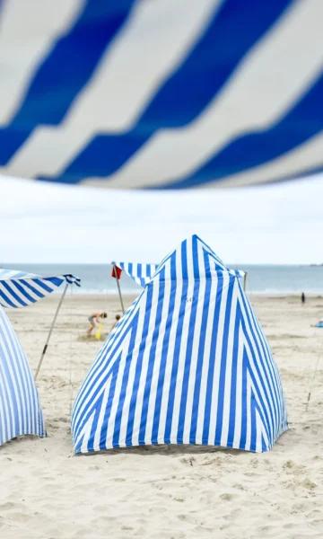 Tentes de Dinard aux rayures blanches et bleues dressées sur la plage de l'écluse en juillet et août. Crédit : A. Lamoureux