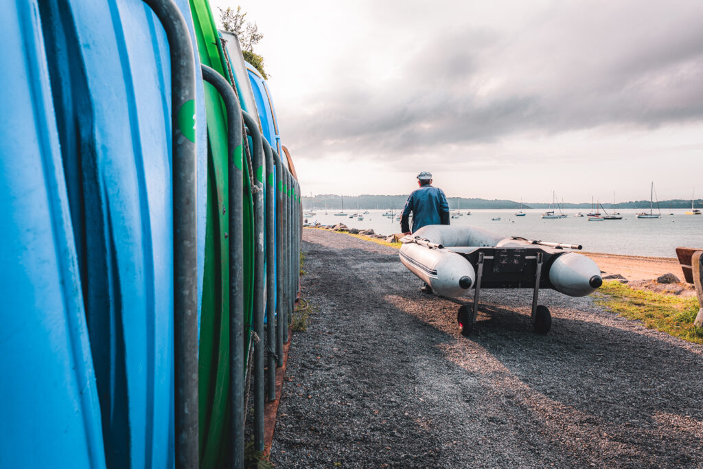 Un homme tire une annexe de bateau juqu'à la plage de Garel au Minihic Sur Rance.