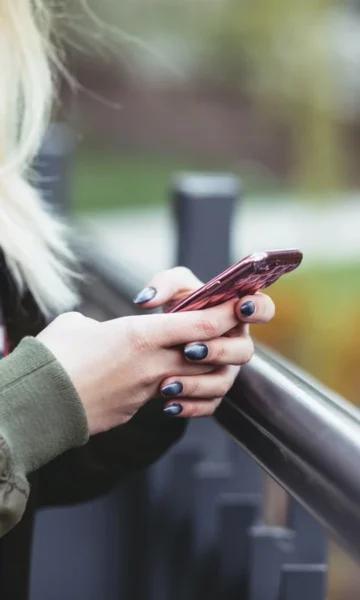 Une femme joue au géocaching sur son smartphone avec l'application gratuit Trésors de Haute Bretagne. De nombreuses quêtes à terminer sur la côte d'Emeraude.