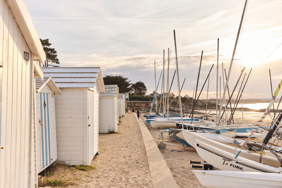 Plage De Saint Sieu à Lancieux au coucher du soleil, entre cabines de plage et catamarans.