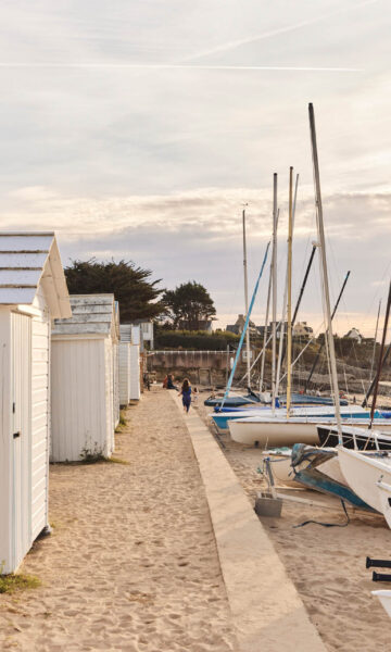 Plage De Saint Sieu à Lancieux au coucher du soleil, entre cabines de plage et catamarans.