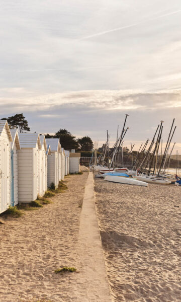 Coucher de soleil sur la plage de Saint Sieu à Lancieux. On aperçoit des bateaux de l'école de voile sur la plage. le soleil apporte une lumière douce donnant à la photo un esprit bohème.