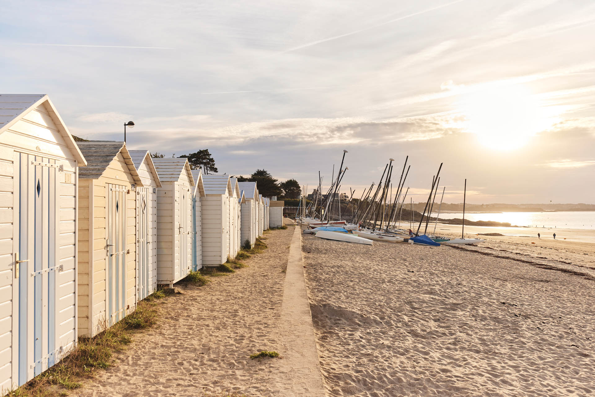 Coucher de soleil sur la plage de Saint Sieu à Lancieux. On aperçoit des bateaux de l'école de voile sur la plage. le soleil apporte une lumière douce donnant à la photo un esprit bohème. Vacances responsables