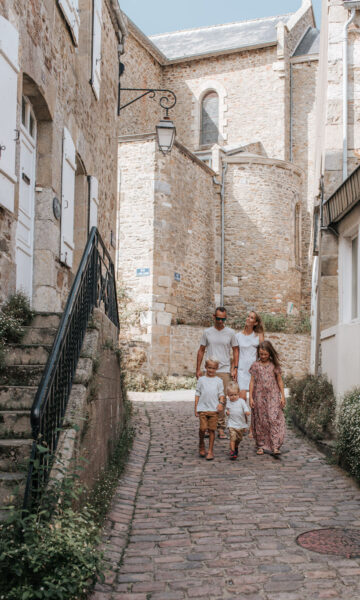 Une famille se promène dans Les Venelles De Saint Briac, au milieu des anciennes maisons de marins.