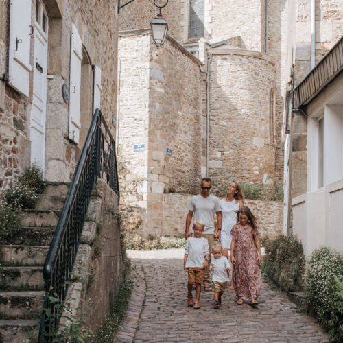 Une famille se promène dans Les Venelles De Saint Briac, au milieu des anciennes maisons de marins.