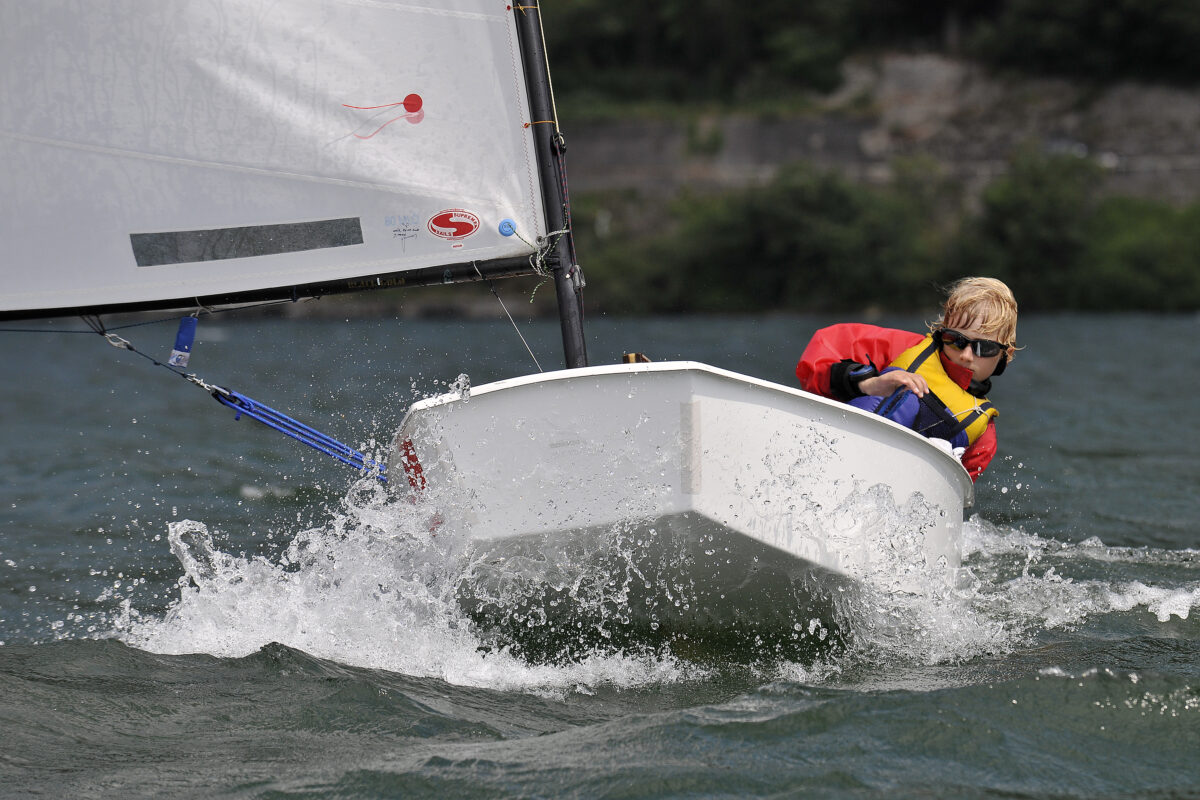 Un enfant tient la barre d'un voilier lors de la Volvo Cup 2009. Des stages nautiques organisés à Dinard Côte d'Emeraude permettent d'apprendre aux enfants la navigation à la voile.