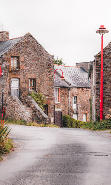 Ruelle du centre-bourg du Minihic Sur Rance, village des bords de Rance. Des fleurs poussent au pied des maisons en pierre typiques de Bretagne.