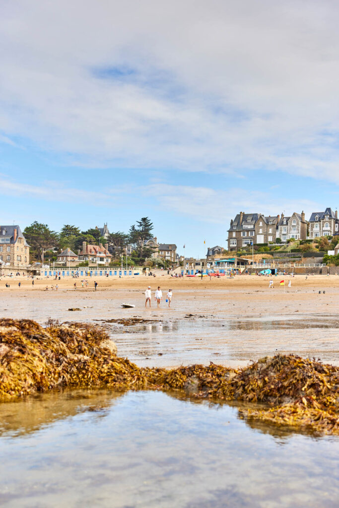 Scène estivale à Dinard sur la Plage de Saint Enogat avec les villas balnéaires.