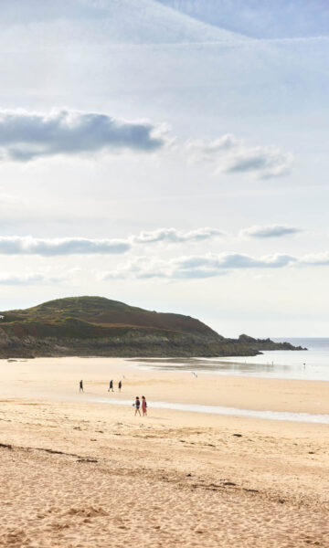 La plage de Longchamp à Saint-Lunaire, et la vue sur la Pointe de la Garde Guérin. Cette plage est un spot de surf renommée et très appréciée des familles.