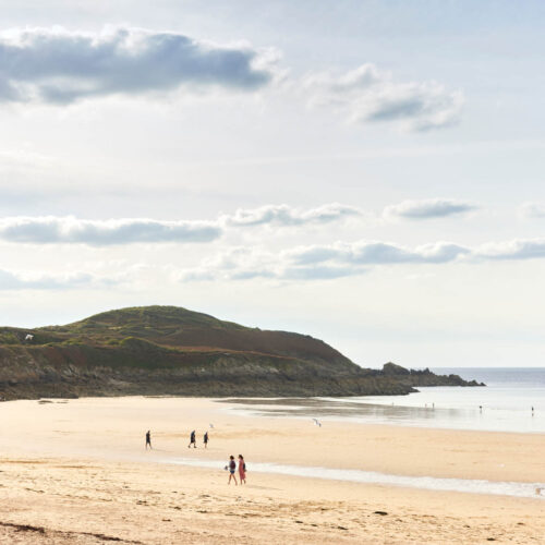 La plage de Longchamp à Saint-Lunaire, et la vue sur la Pointe de la Garde Guérin. Cette plage est un spot de surf renommée et très appréciée des familles.