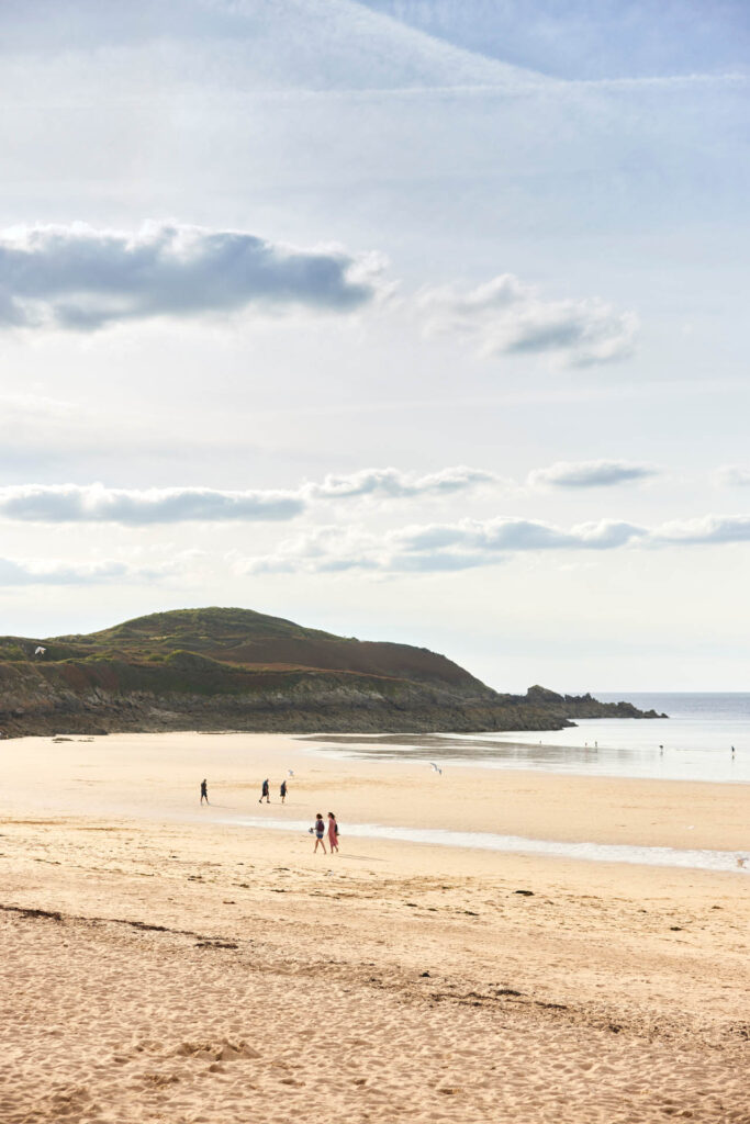 La plage de Longchamp à Saint-Lunaire, et la vue sur la Pointe de la Garde Guérin. Cette plage est un spot de surf renommée et très appréciée des familles.