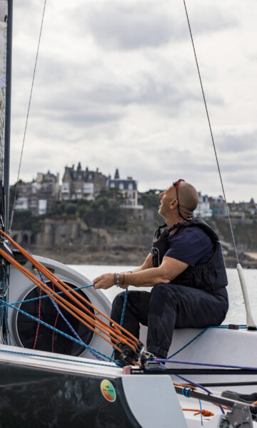 Une famille tient la barre d'un voilier dans la baie de Dinard. La Côte d'Émeraude est un terrain de jeu parfait pour les amateurs d'activités nautiques en Bretagne.