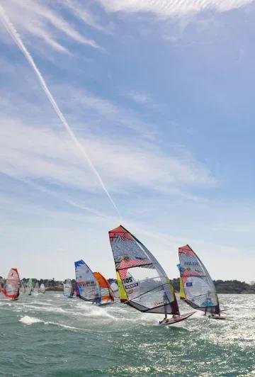 Planches à voile en baie de Dinard. L'école de voile Wishbone Club enseigne aux petits et aux grands les sports nautiques. Wishbone Club est situé à Dinard près de la piscine du pool.