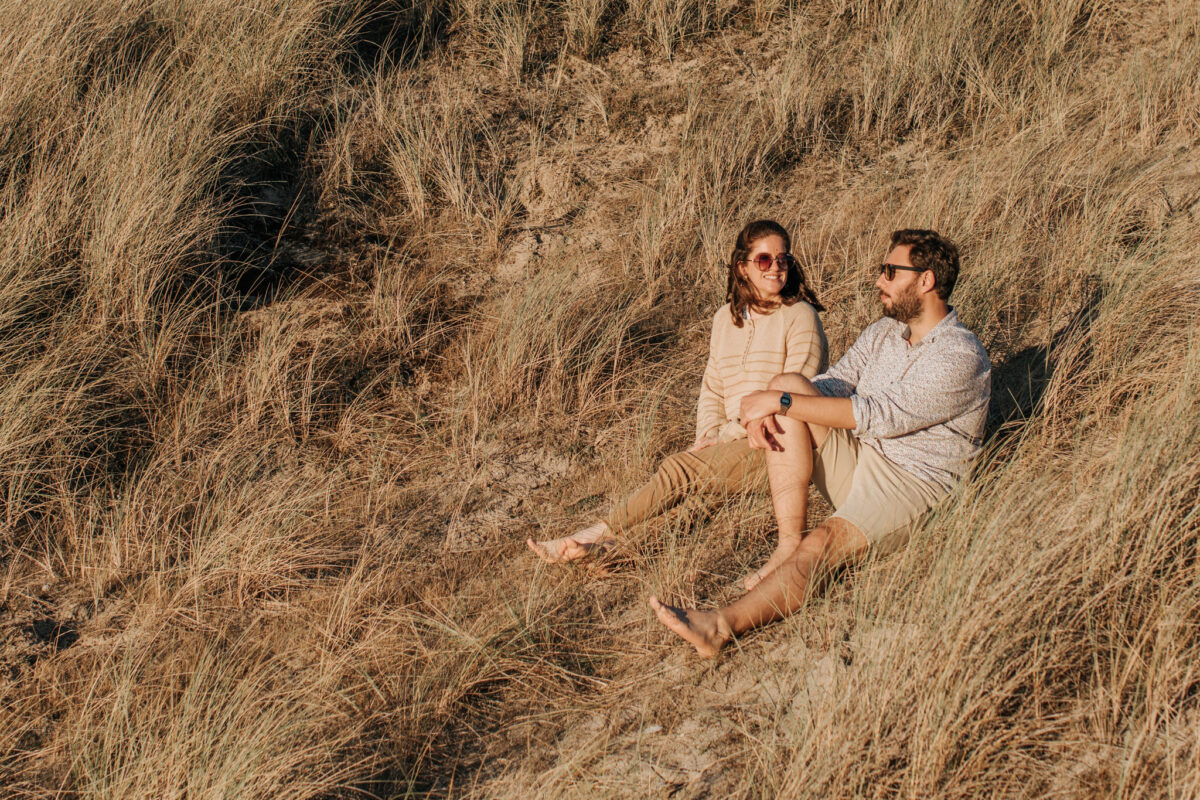 Un couple regarde le coucher du soleil à Lancieux sur la plage des Briantais