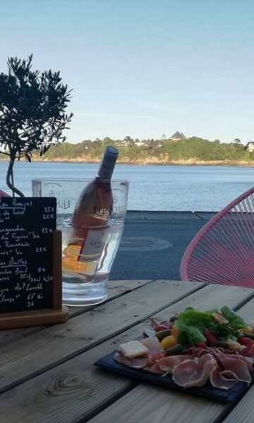 Planche à partager et une bouteille de vin servis au Carthagène, bar et restauration sur le pouce situé sur la plage du Prieuré à Dinard.