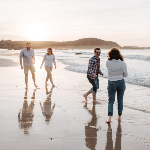 Un groupe d'amis se promène sur la Plage De Lonchamp à Saint-Lunaire au coucher de soleil. Photo : Renaud Photographie