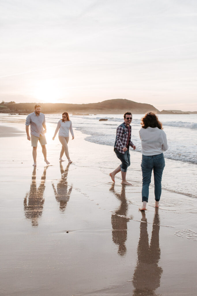 Un groupe d'amis se promène sur la Plage De Lonchamp à Saint-Lunaire au coucher de soleil. Photo : Renaud Photographie