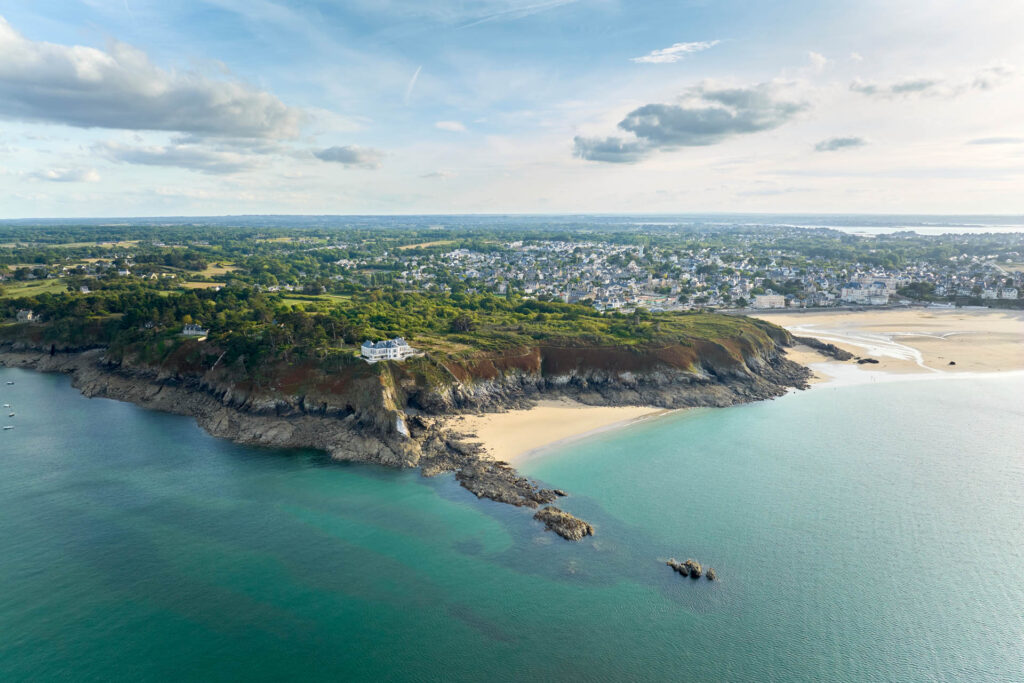 Pointe Du Nick à Saint-Lunaire. Les nuances émeraude dans l'eau caractérisent bien la côte. La végétation est omniprésente. La photo reflète des paysages et espaces préservés. Vacances responsables