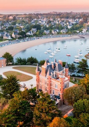 Photo aérienne de la presqu'île du Nessay avec l'hôtel du Nessay et la plage du bechet en fond. les couleurs sont très douce et aspirent aux vacances.