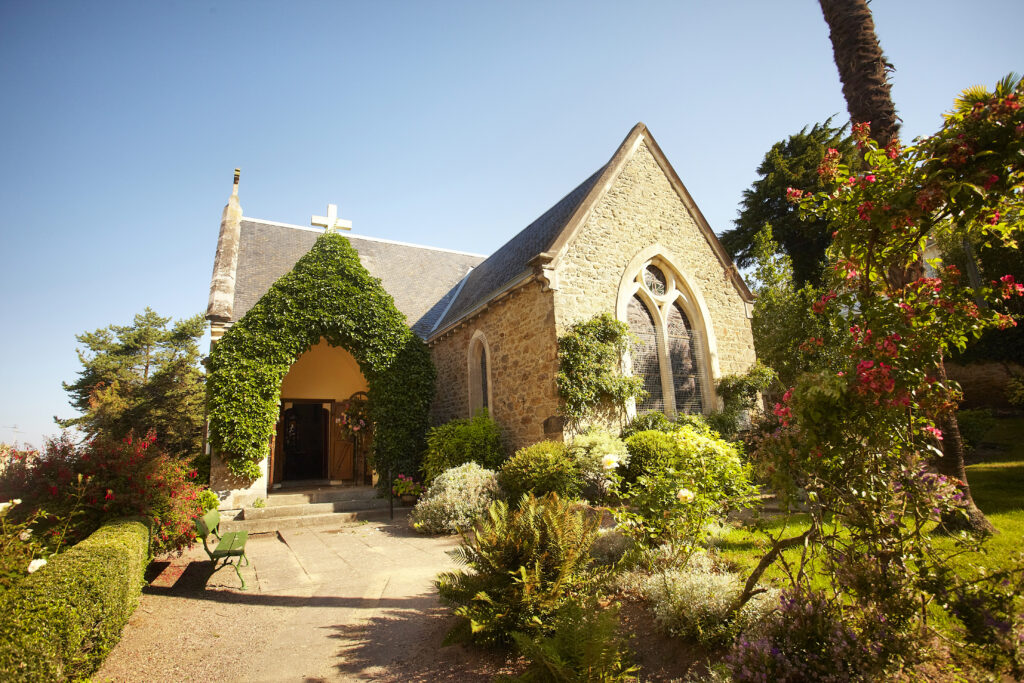 English Touch photo de la chapelle anglicane sous un ciel bleu. La végétation est luxuriante Visites guidées groupe à Dinard Côte d'Émeraude.