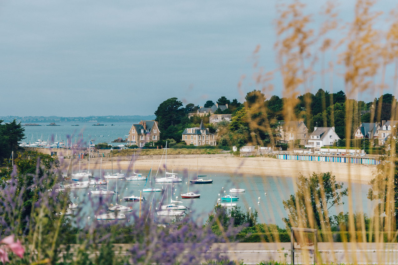 Saint-Briac-sur-Mer, la plage du Béchet et ses bateaux vue depuis le jardin Armel Beaufils. De jolies maisons bordent la plage. Crédit : Loeildeos